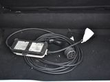 a cable connected to a charger in the trunk of a car