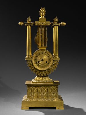 une horloge en or posée sur un socle