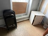 a black suitcase sitting next to a window in the corner of a room