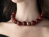 a woman that is wearing a necklace made of wood beads