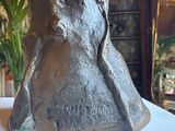 a bronze statue of a man with a hat on a table