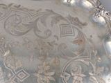 an antique silver tray with a floral design on it