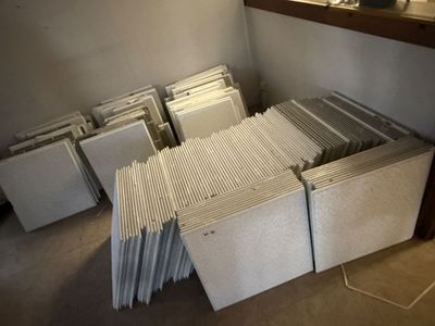 une pile de livres posée par terre dans une pièce