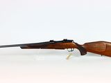 a rifle on a white surface with a white background