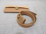 a close up of a belt and a wallet on a bed
