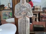 une statue représentant un homme debout devant un miroir