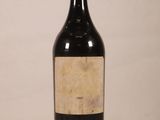 une vieille bouteille de vin posée sur une table blanche