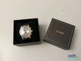une image montrant un gros plan d'une montre dans un coffret posé sur une table