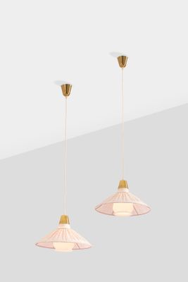 a pair of pink and gold pendant lights hanging from the ceiling
