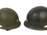 pair of wwii era german steel helmets on a white background