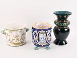 trois vases posés l'un à côté de l'autre sur une surface blanche