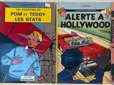 Quatre bandes dessinées anciennes sont alignées sur une étagère