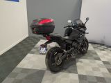 a black motorcycle parked in a room with a checkered floor