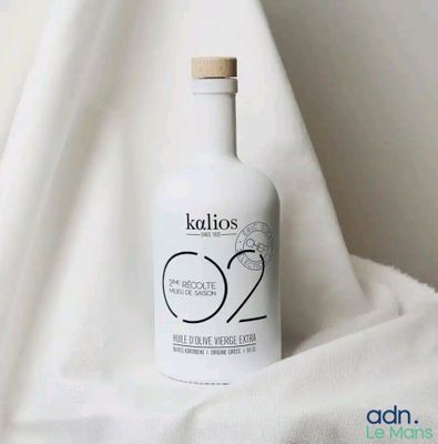 a bottle of liquid sitting on a white cloth