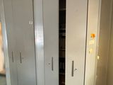 un placard dans un coin d'une pièce, dont la porte est ouverte