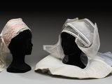 deux têtes de mannequin coiffées, exposées sur une surface grise
