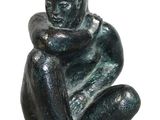 statue of a man sitting on a rock with his hands on his knees