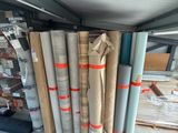 several rolls of fabric are stacked up in a storage area
