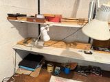 a desk with a lamp, a lamp shade, and other items on it