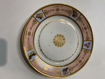 une assiette ornée d'un motif doré et rose