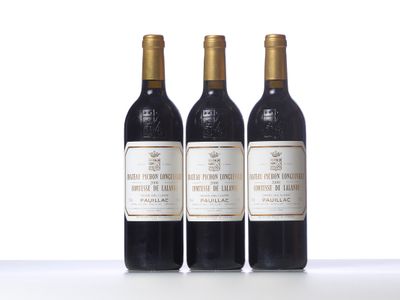three bottles of wine are lined up on a white surface
