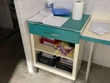 a small desk with a blue drawer and a roll of toilet paper on it