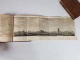 an open book with a picture of a city on it