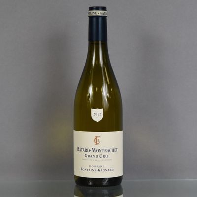 a bottle of white wine sitting on a glass table