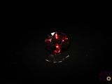 un gros plan d'une boule de verre rouge posée sur une surface noire