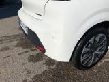 the rear end of a white car parked in a parking lot