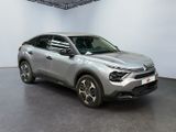 a silver car is parked in a large room with a white wall
