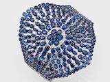 un gros plan sur une bague sertie d'un saphir bleu et de diamants