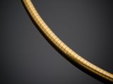 a gold snake necklace on a black background