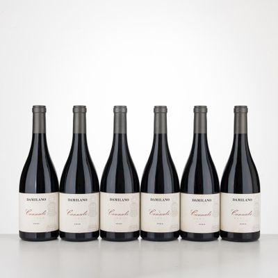 four bottles of red wine lined up on a table