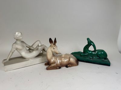 three figurines of a woman and a deer on a table