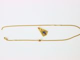 une photo d'un collier en or orné d'une pierre bleue