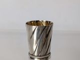 a close up of a silver cup sitting on a table