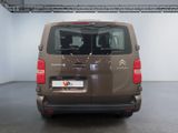 the back of a brown van parked inside of a building