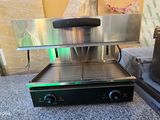 a grill that is sitting on the floor next to a couch