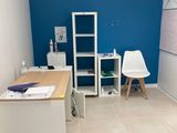 une pièce équipée d'un bureau, d'une chaise et d'un réfrigérateur