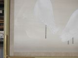 a painting of two white birds on the wall