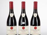 trois bouteilles de vin rouge posées sur une table