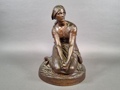 bronze statue of a woman sitting on a rock with her hands on her knees