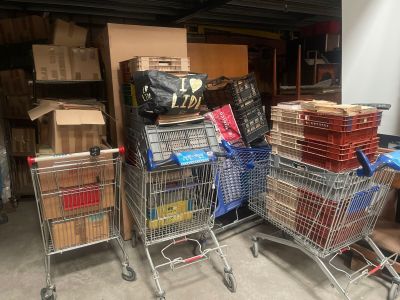 plusieurs caddies avec des cartons empilés dessus dans un garage