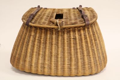 an image of a wicker bag with leather straps on a white background