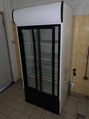 un réfrigérateur qui se trouve dans le coin d'une pièce