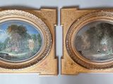pair of paintings of a landscape in a gilded frame on a wall