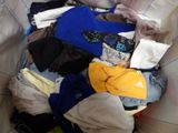 a pile of clothes in a bin on the floor