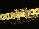 an image of a gold bracelet on a black surface