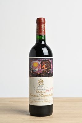 the bottle of red wine is sitting on a wooden table